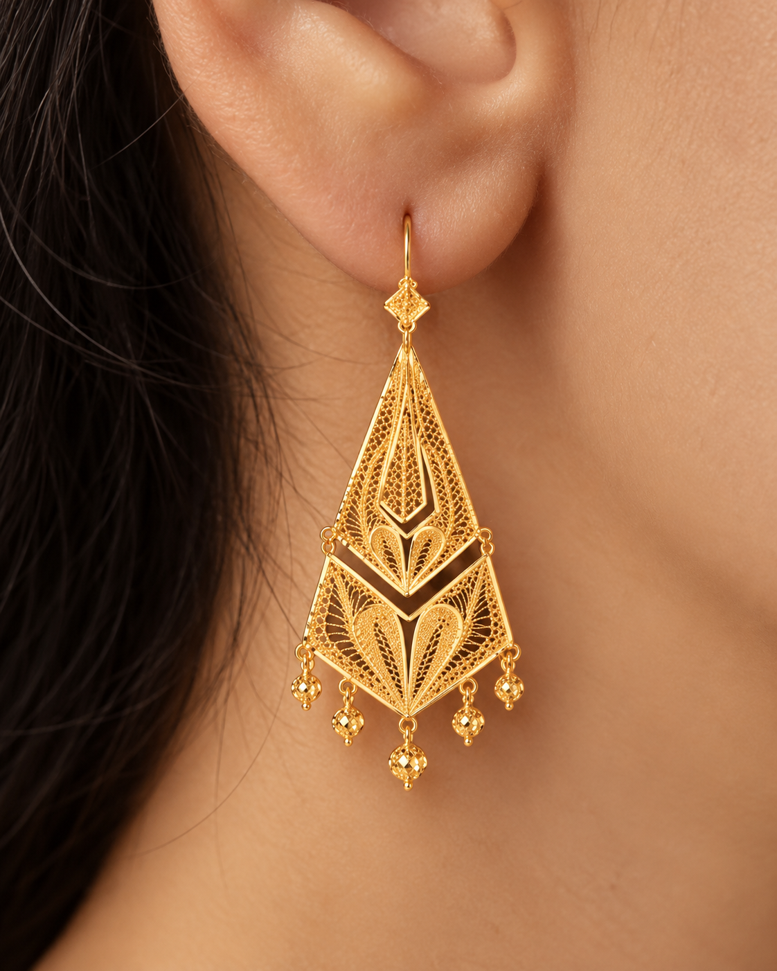 Long kite-shaped gold filigree earrings with heart motifs and bead fringe