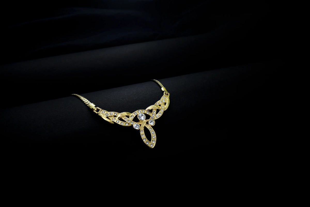 A gold necklace on black