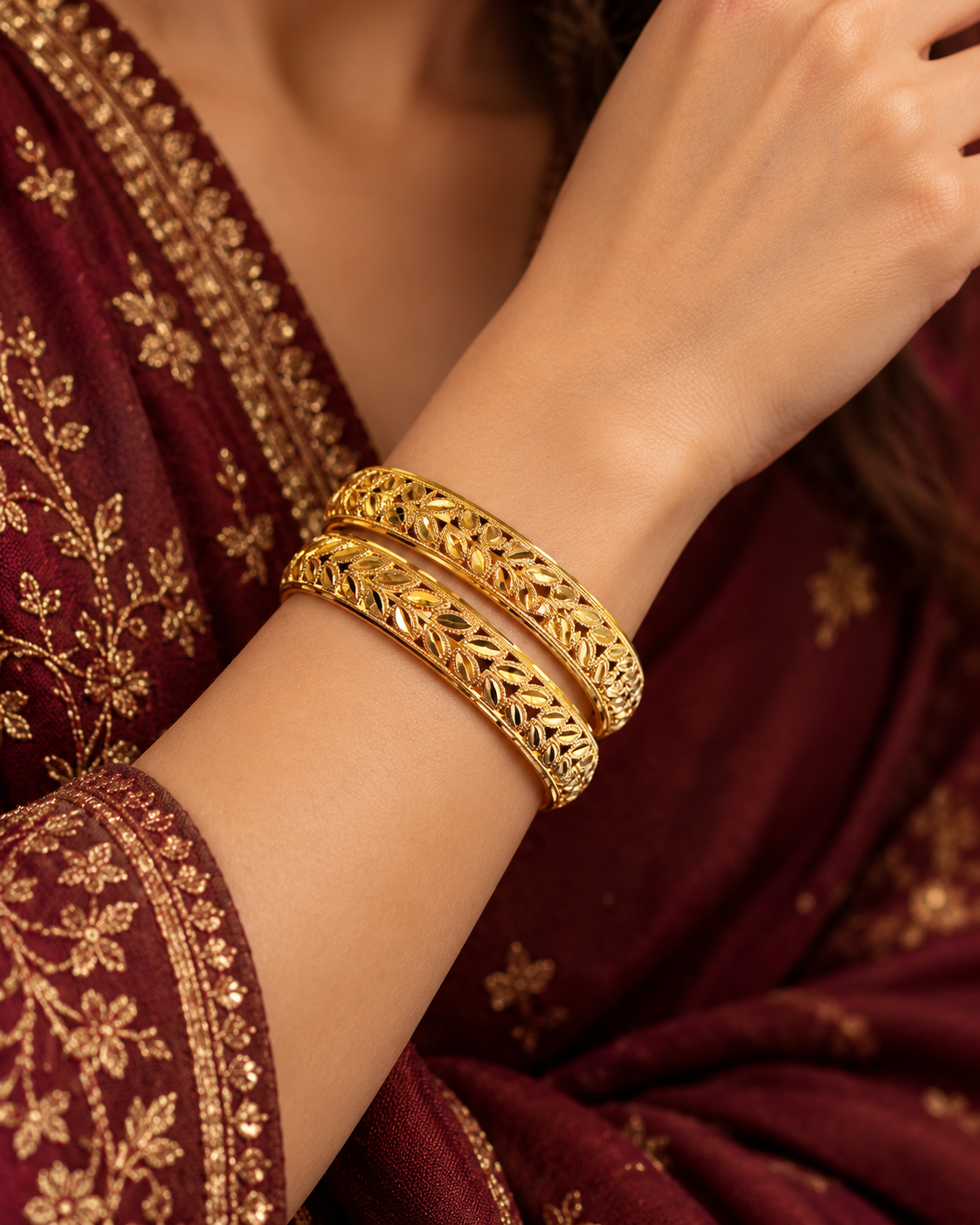 Pair of openwork gold bangles with diamond-cut leaf pattern