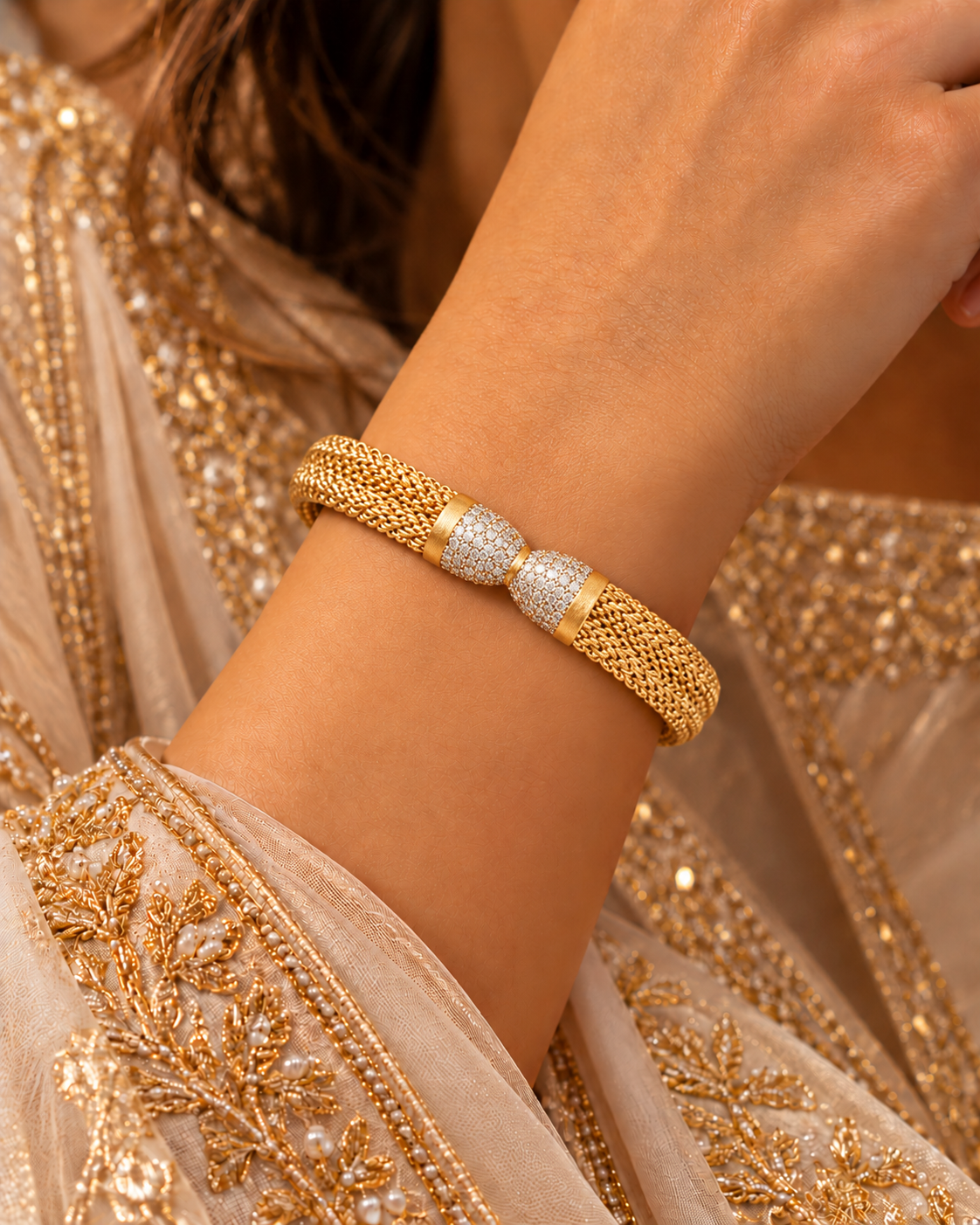 Wide gold mesh bangle with a pavé white-stone bow centrepiece