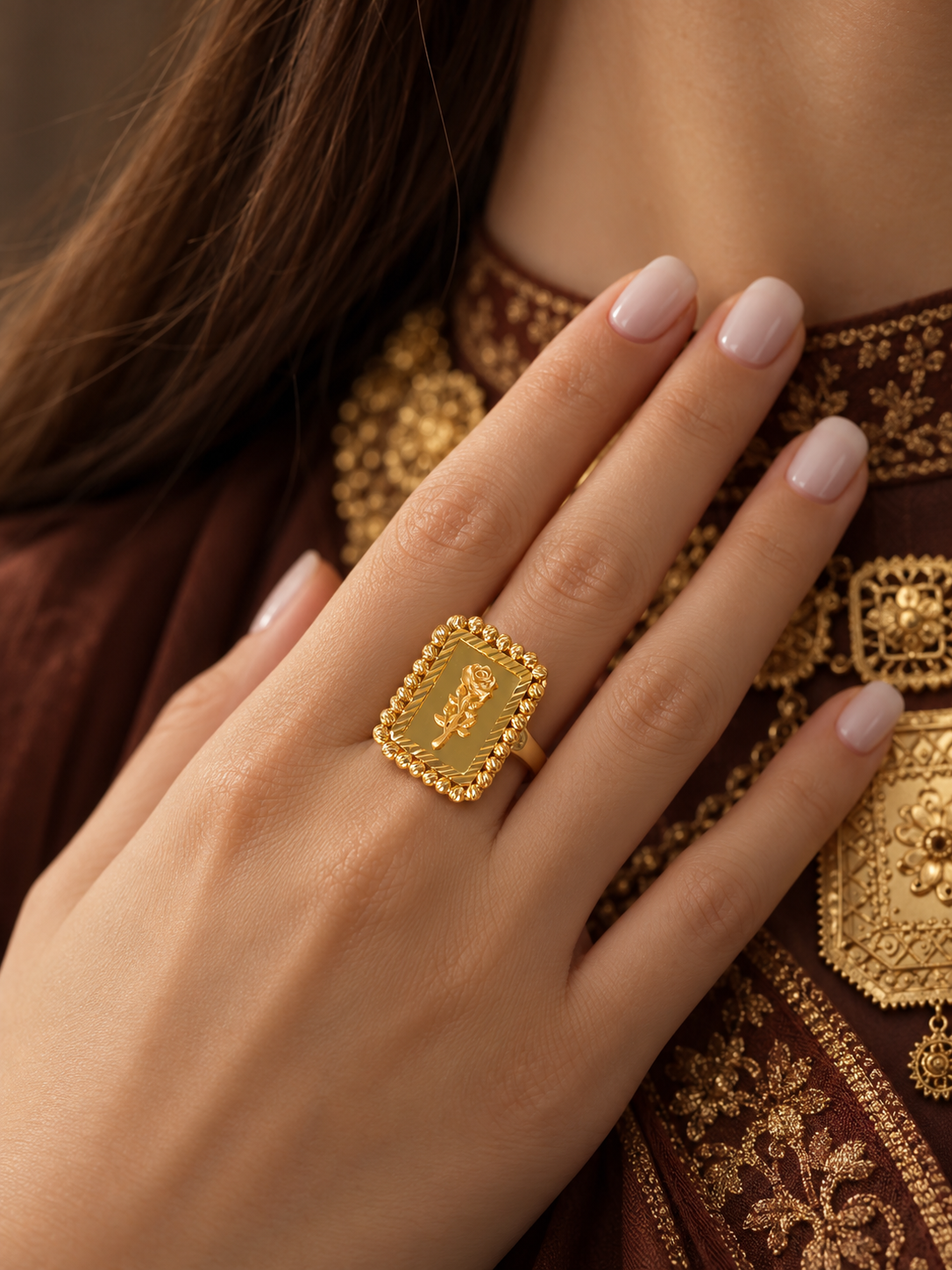 Rectangular gold ring with an engraved rose and beaded frame