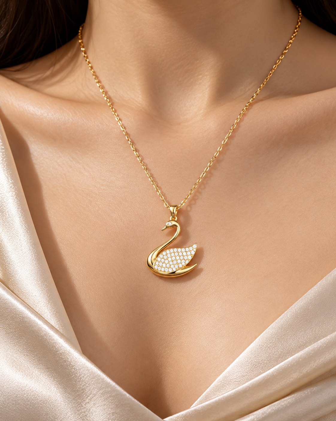Gold swan pendant necklace on a fine gold chain, close-up